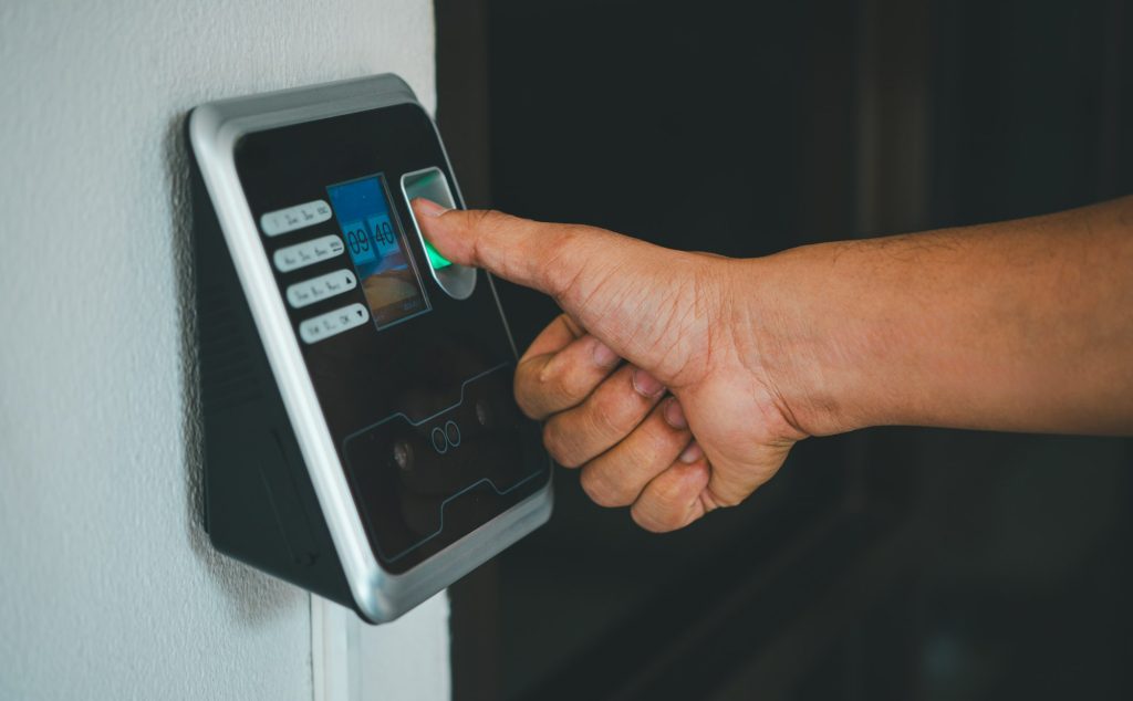 A person is using a fingerprint reader to access a building